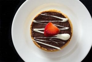 Chocolate Mousse Dessert with White Chocolate Drizzle and Fresh Cut Strawberry