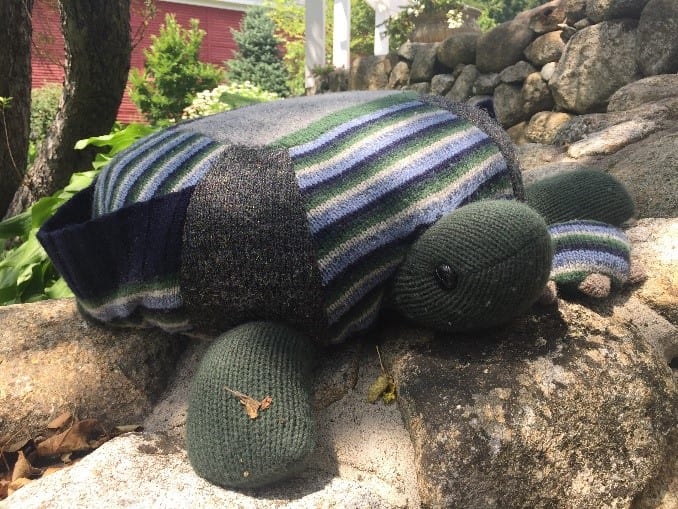 Soft toy turtle made from wool in the garden